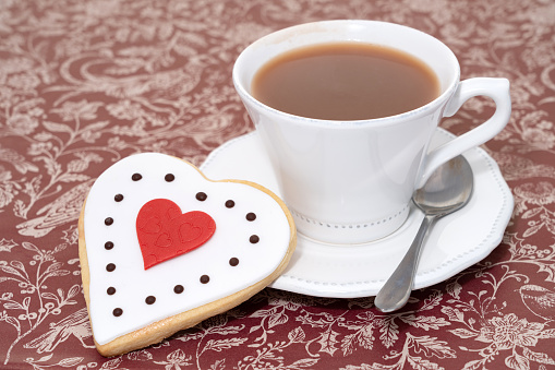 Mugs cups of coffee or tea for two lovers honeymoon wedding morning in coffee shop with green nature in background. Copy space with white wooden table. Valentines day concept.