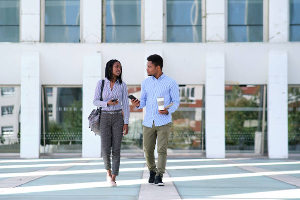 istock Business people leaving a building while chatting and drinking coffee 1462780136