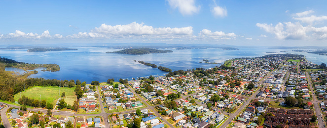 Elevated aerial panorama of lakeshore at Swansea coastal town on Lake Macquarie waterfront of Australia.