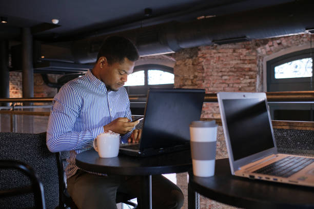 istock African businessman using a mobile in a coworking cafeteria 1462784164