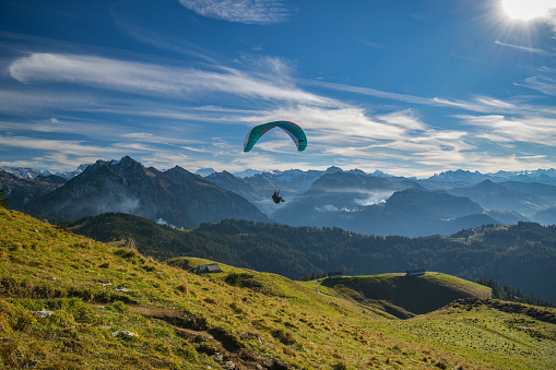 Sattelegg, Switzerland - October 31, 2020: Paraglider enjoying flight above Swiss Alps close to Sattelegg in Switzerland in autumn 2020