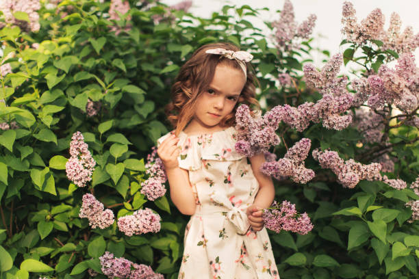 Little girl in dress on flowers background. stock photo
