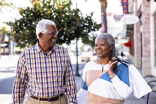 A senior black couple shopping downtown during the daytime