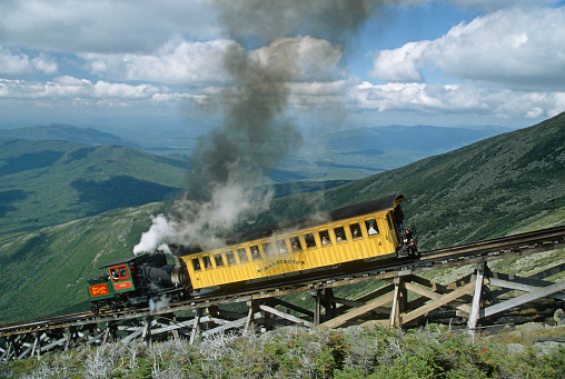 With people looking out the windows, the “Summit” steam engine and passenger car descends near the Jacob's Ladder trestle on the historic Mount Washington Cog Railway in New Hampshire on September 3, 1998.