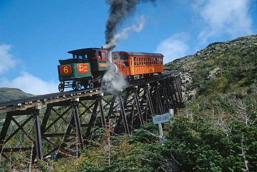 Number 6 steam engine puffs its way up and over Jacob's Ladder trestle with a passenger car on the historic Mount Washington Cog Railway in New Hampshire on September 3, 1998.