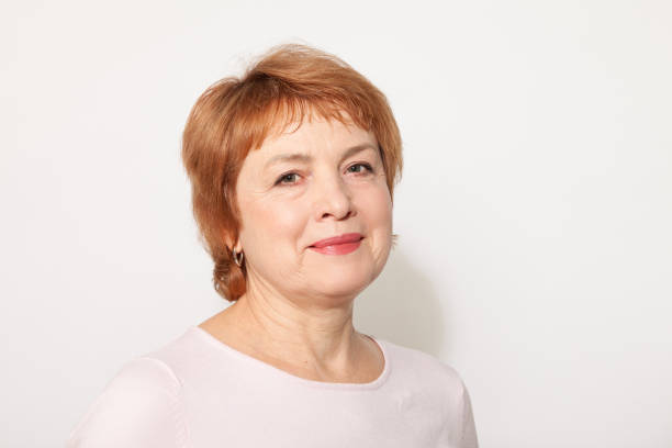 Studio portrait of a white active senior woman with red hair on a white background stock photo