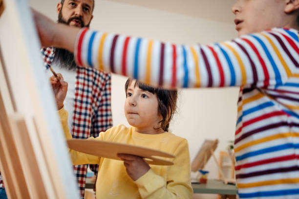istock Art teacher showing kids how to paint 1462813795