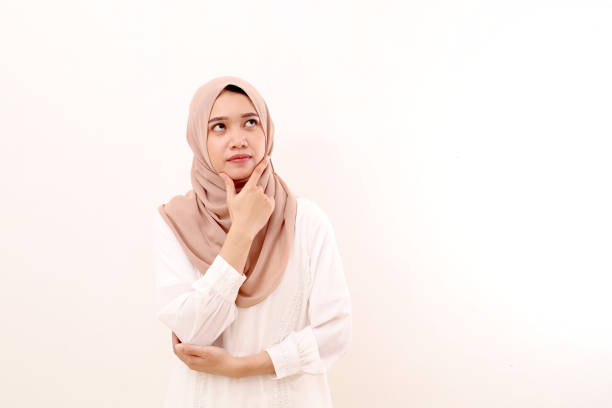 istock Thoughtful young asian muslim woman standing while thinking something. Isolated on white background 1462815712