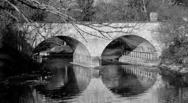 istock IMAGE BLACK & WHITE OF STONE BRIDGE - 
RIPPLED REFLECTION IN SPRING 1462819027