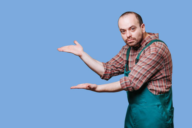 istock a man dressed in coveralls, has an emotional expression as he has his hands spread 1462826390