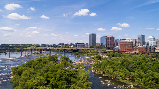 Aerial skyline of Downtown Richmond, Virginia. The distant view over the James River and surrounding parks and wooden natural areas.