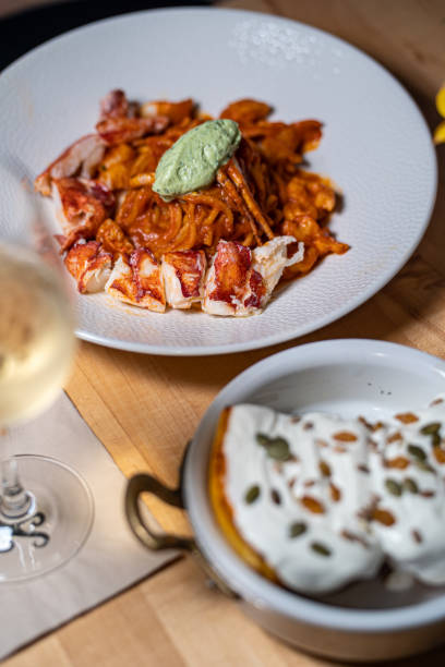 Spaghetti Frutti di Mare on a table set with glass of wine stock photo
