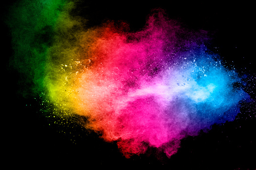 Launched multicolored powder on black background.Color powder explosion.Colorful dust splashing.