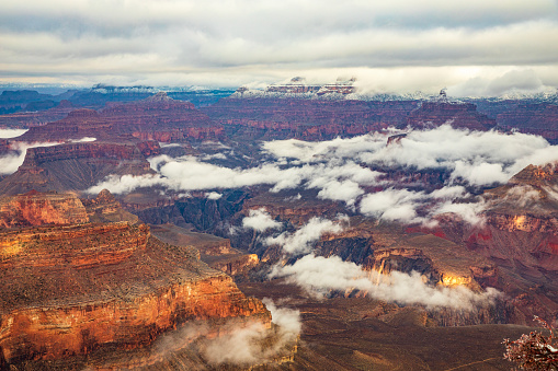 Winter canyon land scene in the Grand Canyon with clouds and mist.