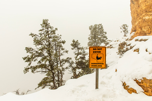 Warning sign of danger of cliffs in the snow