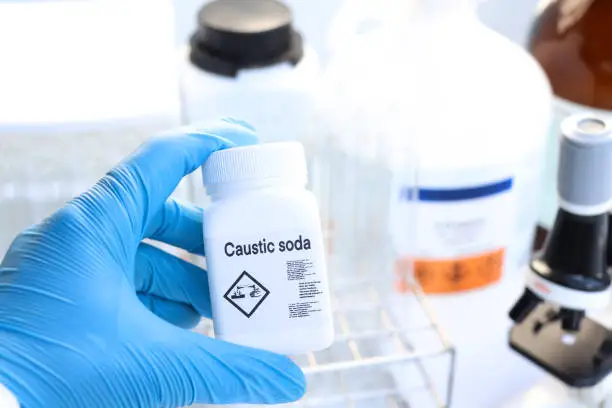 Photo of caustic soda in bottle , chemical in the laboratory and industry