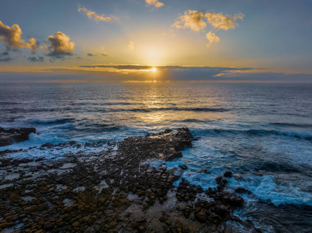 istock Sunrise over the ocean and rock platform 1462867297