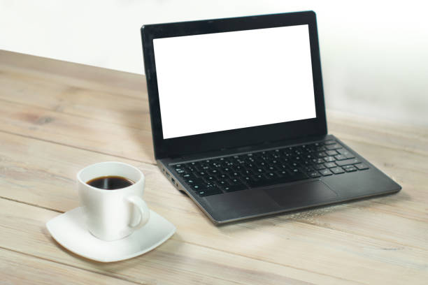 a cup of coffee next to a laptop with a blank screen