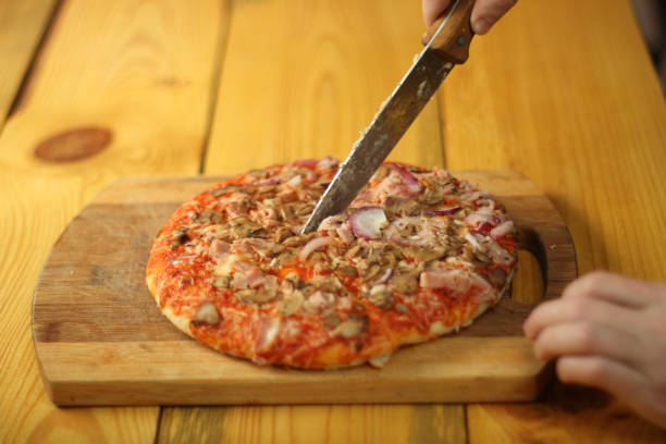 istock cutting pizza on the bottom with a knife 1462867767
