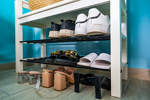 women's shoes in the home shoe cabinet - detail of a domestic corner dedicated to footwear for her - lifestyle concept