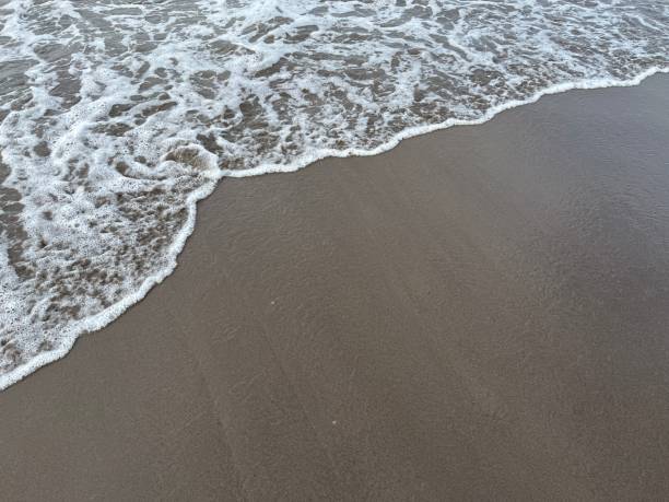istock Soft wave of the ocean with black sand 1462908207