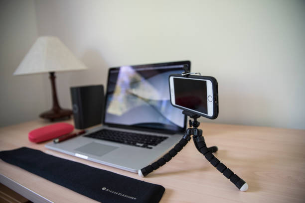istock Mobile phone on tripod near computer equipment on office desk 1462922534