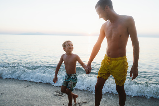 Photo of a young man and his son enjoy being at the beach in the afternoon