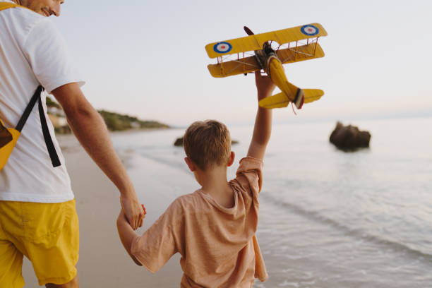 istock Playing with an airplane toy at the beach 1462924423