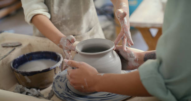 istock Hands, pottery teacher and child with bowl in clay workshop classroom, teaching and learning in creative studio. Education, creativity and art, girl in sculpture class with woman making pot or vase. 1462929419