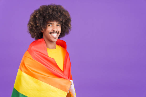 istock Happy african man wrapped with a lgbt flag 1462931586