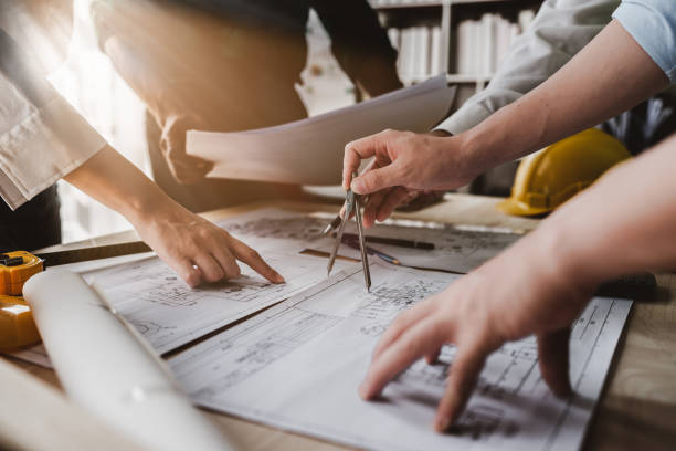 equipe de arquitetos trabalhando com projetos para plano arquitetônico, engenheiro esboçando um projeto de construção, conceito de energia verde - encolher - fotografias e filmes do acervo