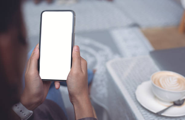 istock Cell phone mockup image blank white screen.  Woman hand holding, using mobile phone at home. 1462934731