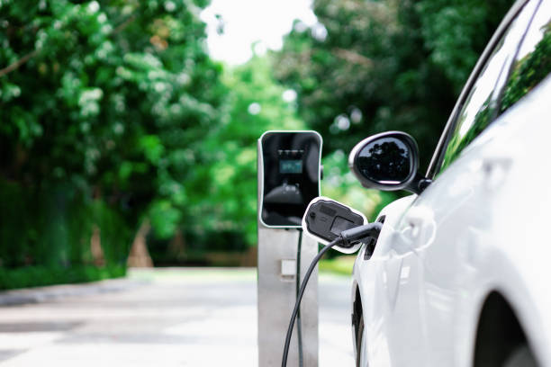 focus closeup ev car and charger with blur background for progressive concept - elektrikli araba lar stok fotoğraflar ve resimler