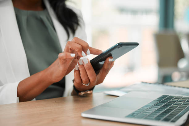 teléfono, oficina y redes de mujeres de negocios en las redes sociales, internet o una aplicación móvil. líder de tecnología, empresa corporativa y profesional navegando en un dispositivo móvil en su lugar de trabajo moderno. - solitario fotografías e imágenes de stock