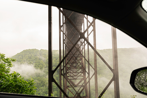 Underbelly of the New River Gorge Bridge on a cloudy rainy day seen from a car window, West Virginia, USA