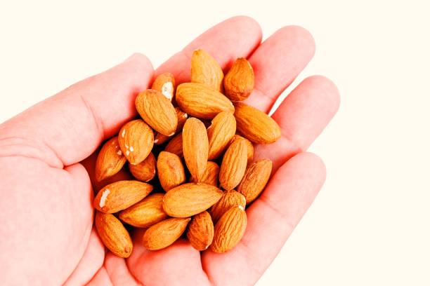 istock Raw Almonds in the hand above white background 1462937085