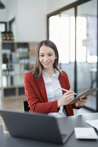 istock business owner or Asian female marketers are using tablet computer in office work 1462938202