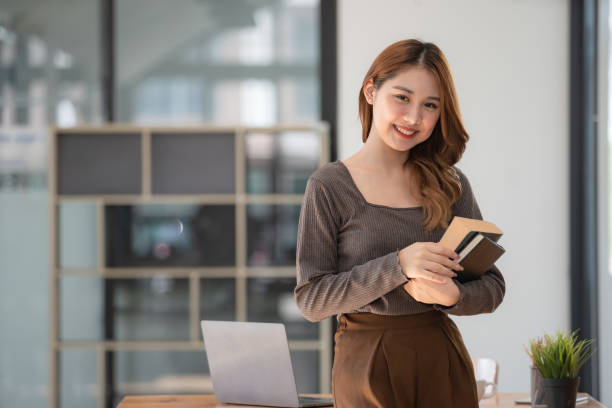 istock Pretty young Asian college student standing while holding books. Back to school concept. 1462938736