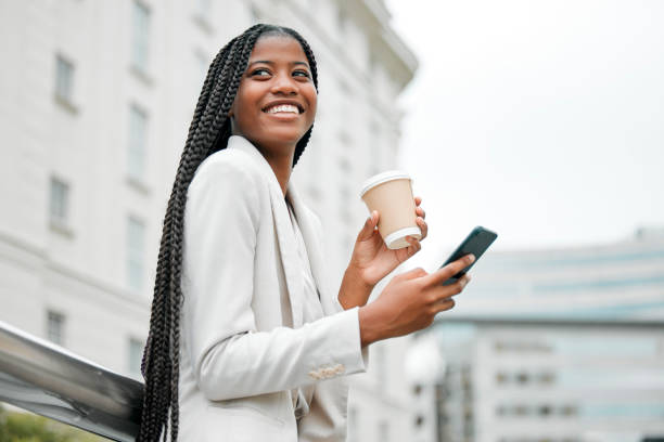business, smartphone or black woman in city, coffee or walking on break, typing or social media. young female, ceo or entrepreneur with tea, phone or connection in street, chatting or search internet - business business person ceo coffee imagens e fotografias de stock