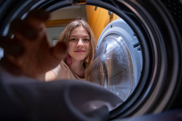istock Young girl helping unload the washing machine at home 1462942539