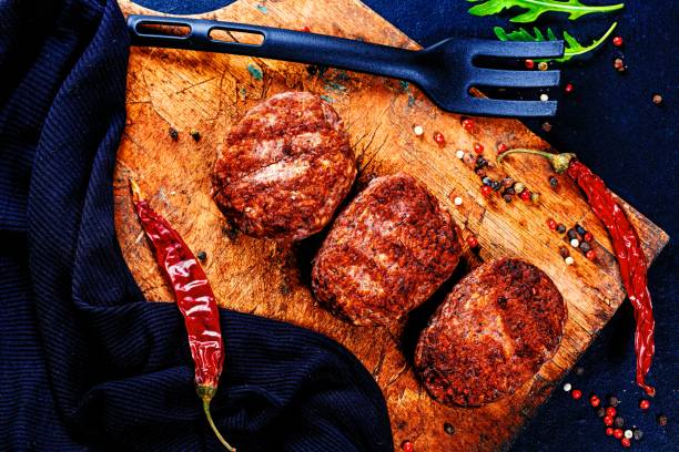 istock Meat cutlets with spices and chili on an old kitchen Board. Top view 1462942983