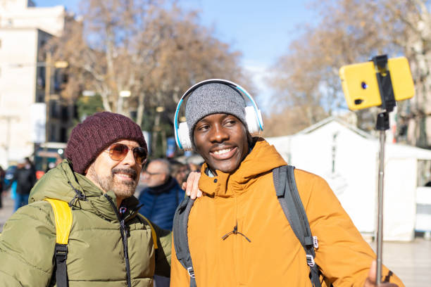 istock Two smiling friends making a video call in the city. 1462943111
