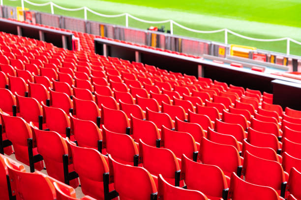 red plastic chair in football, basketball or baseball arena stadium in a row for visitor to visit and enjoy sport match competition for big football match in football stadium stock photo