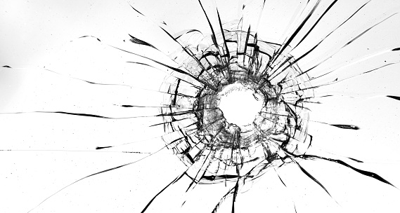 Cracks in the glass on a white background. A bullet hole in the window
