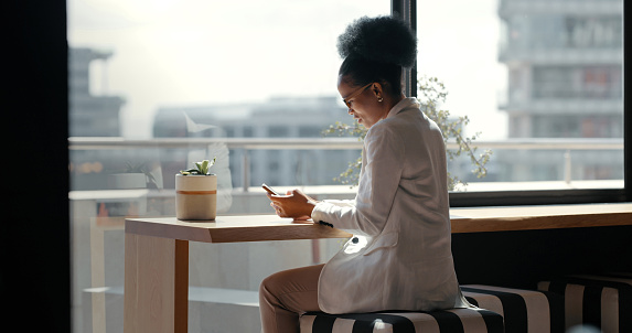 Business, black woman and smartphone for typing, modern office and connection for social media. African American female employee, leader and executive with cellphone, chatting and search internet