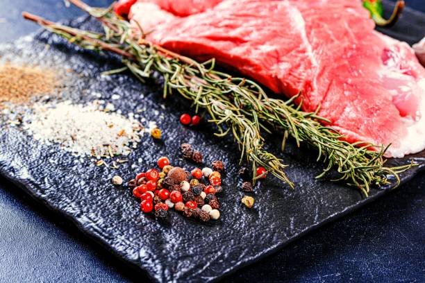 istock Spices and raw meat steak on black background 1462953557