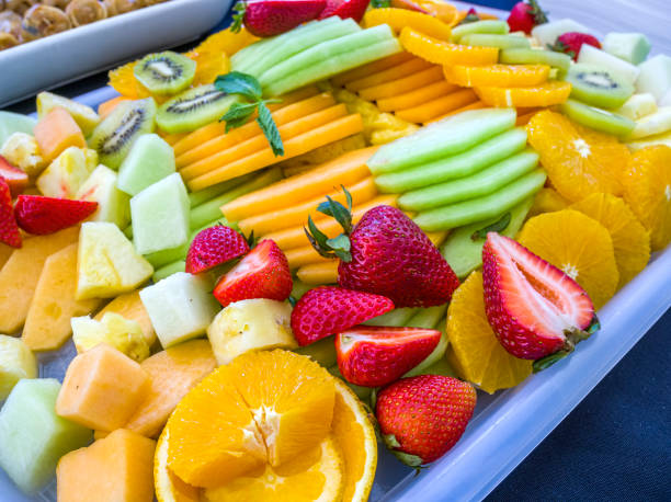 Slices of a variety of fresh fruits served on a tray Slices of a variety of fresh fruits served on a tray in a healthy and colorful catering situation. Close-up view. yellow melons field stock pictures, royalty-free photos & images