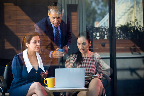 istock Business people drinking coffee and using laptop 1462955864