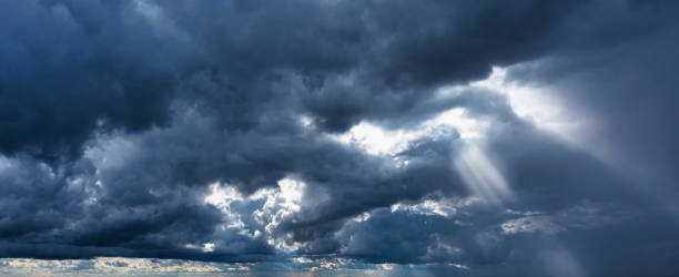 gewitterwolken und sonnenstrahlen auf dunklem hintergrund. - incoming storm stock-fotos und bilder