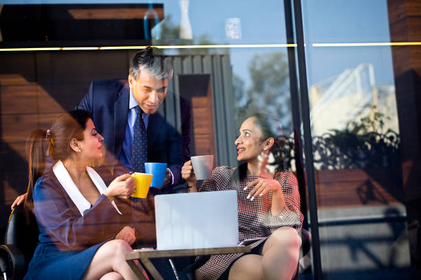 istock Happy business people drinking coffee and using laptop 1462956905